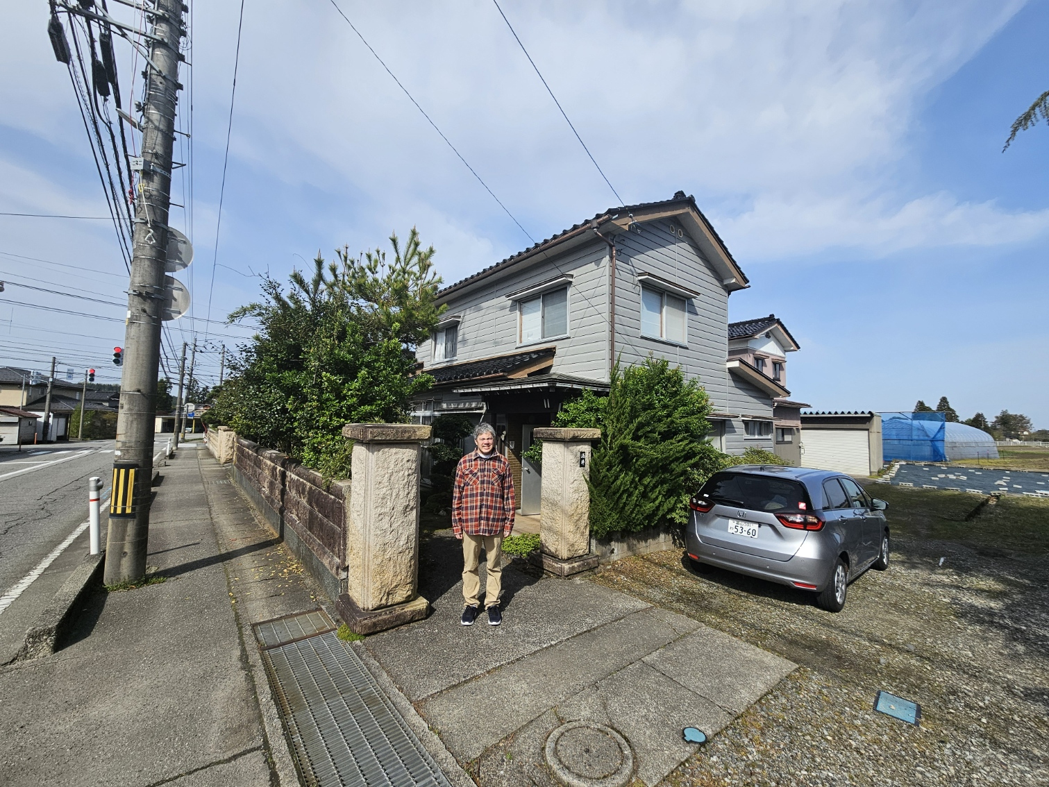 Wide front view of the Hanasaki house with car.