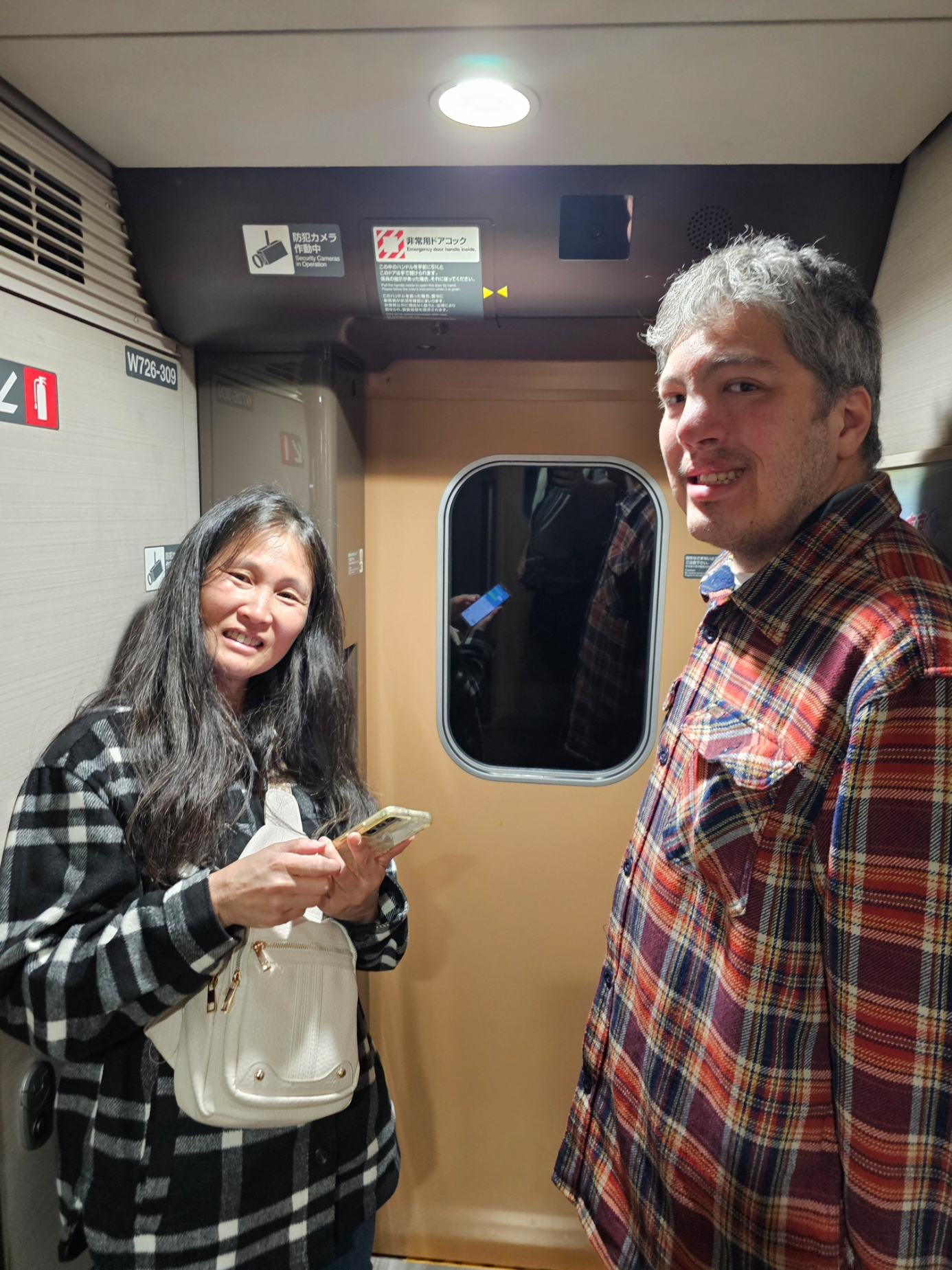 Tomoko and Tatsunari in the train vestibule.